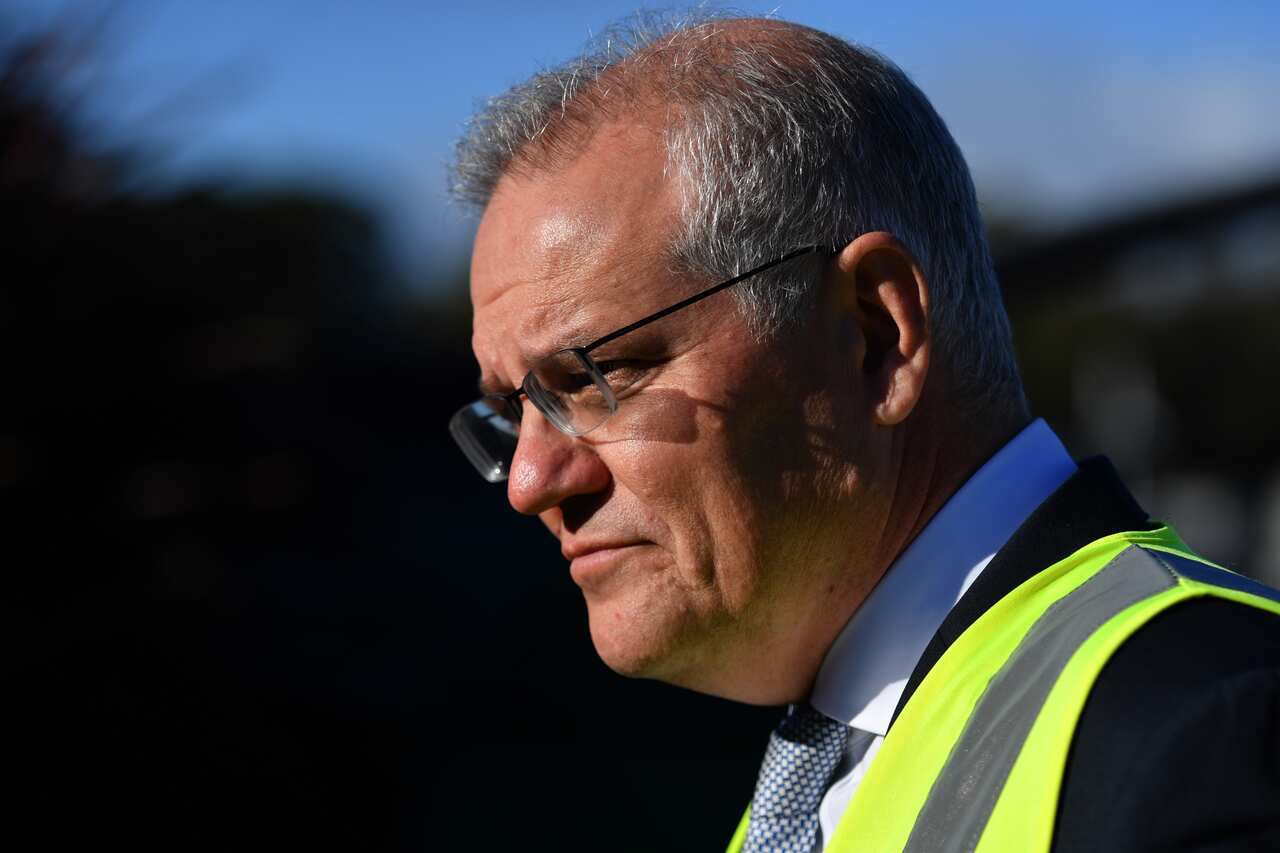 Close up side profile of Scott Morrison wearing a suit and hi-vis. 