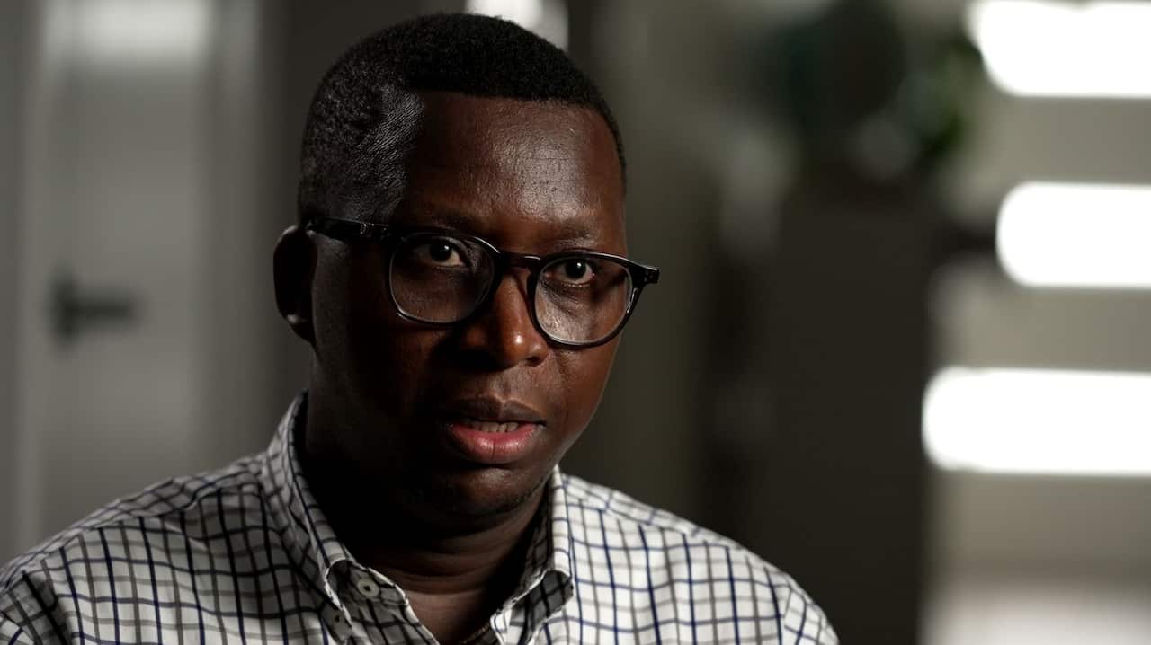 A man wearing glasses and a checked shirt.