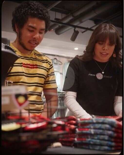 two people folding stock in a store