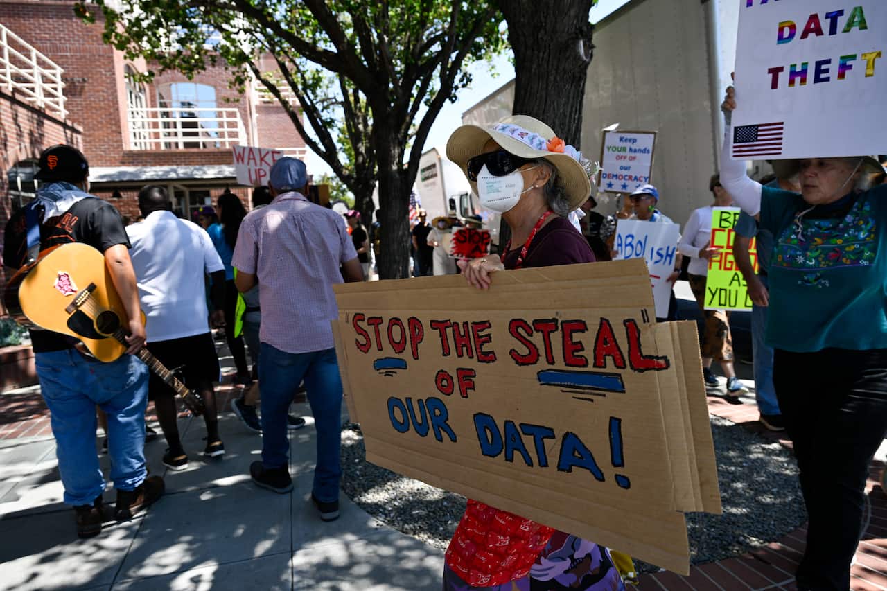Protesters demonstrating against US immigration raids holding a sign that reads "Stop the steal of our data"