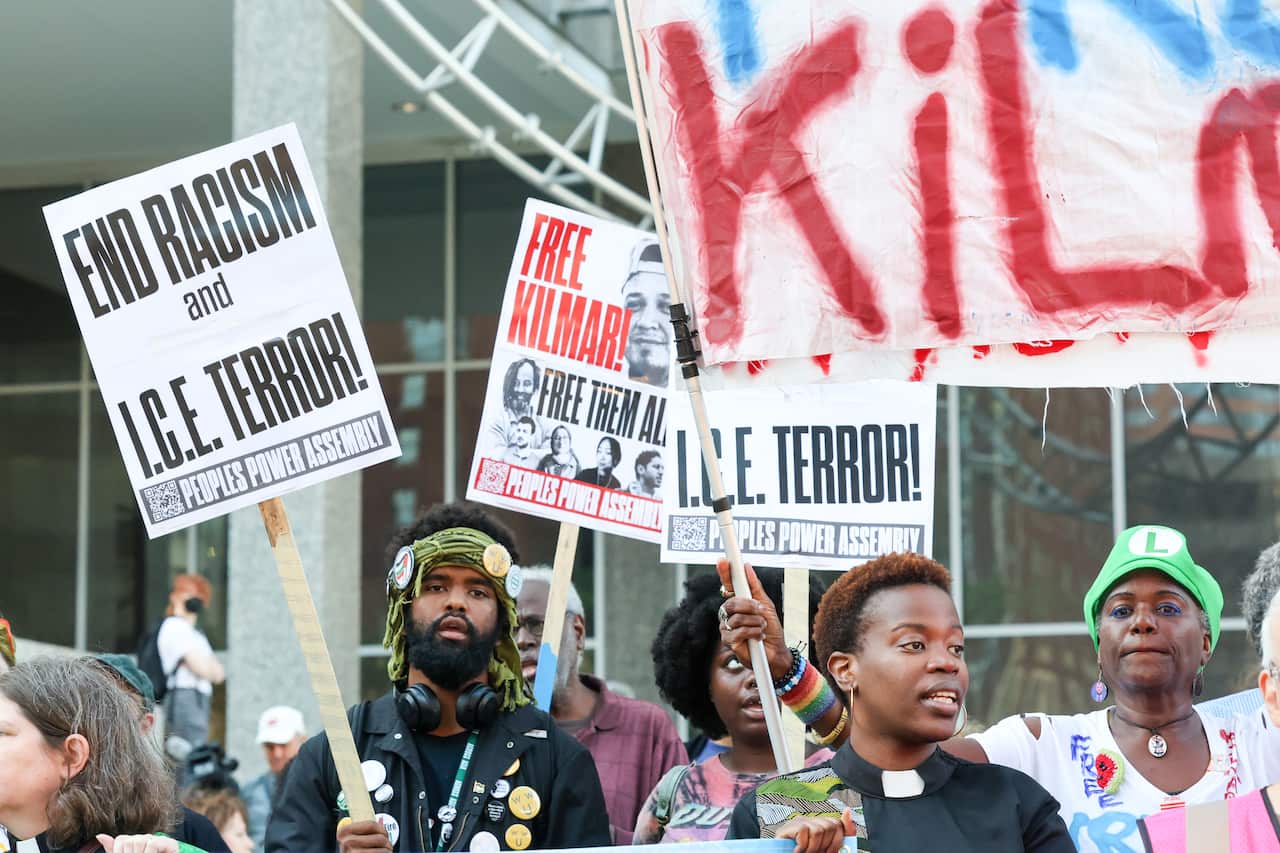 Protesters holding banners outside a building.