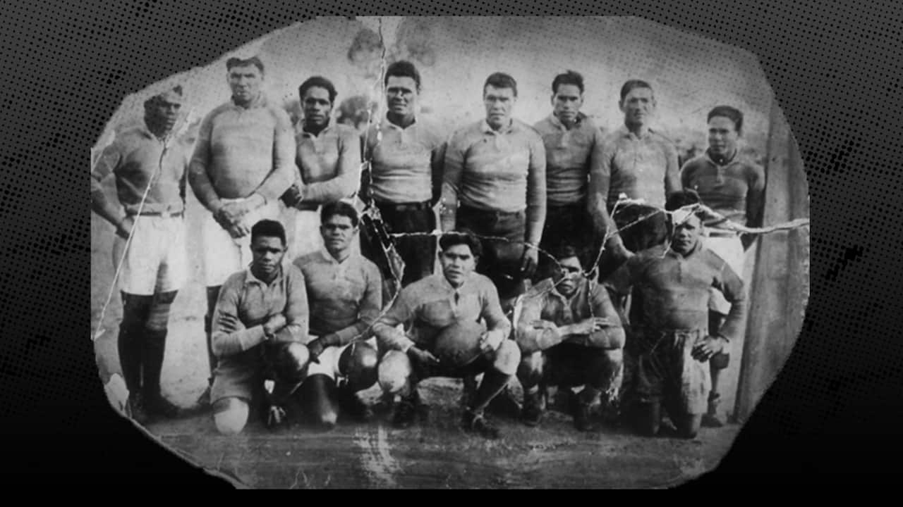 Black and white team photo of the original 1922 Wiradjuri Erambie All Blacks team, two rows of players in their uniforms, crouched down players in the front and taller players behind.