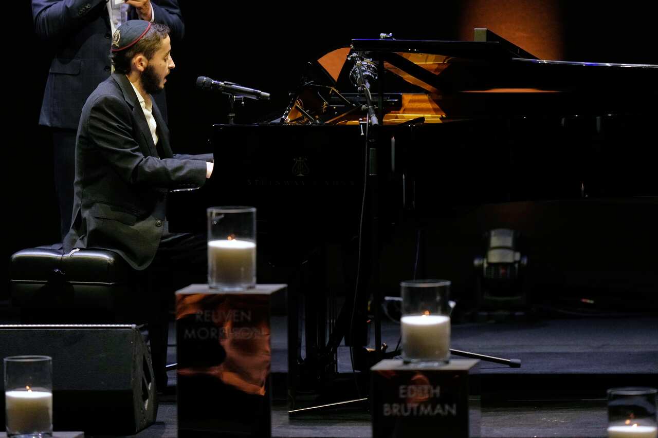 A man plays the piano on a stage.