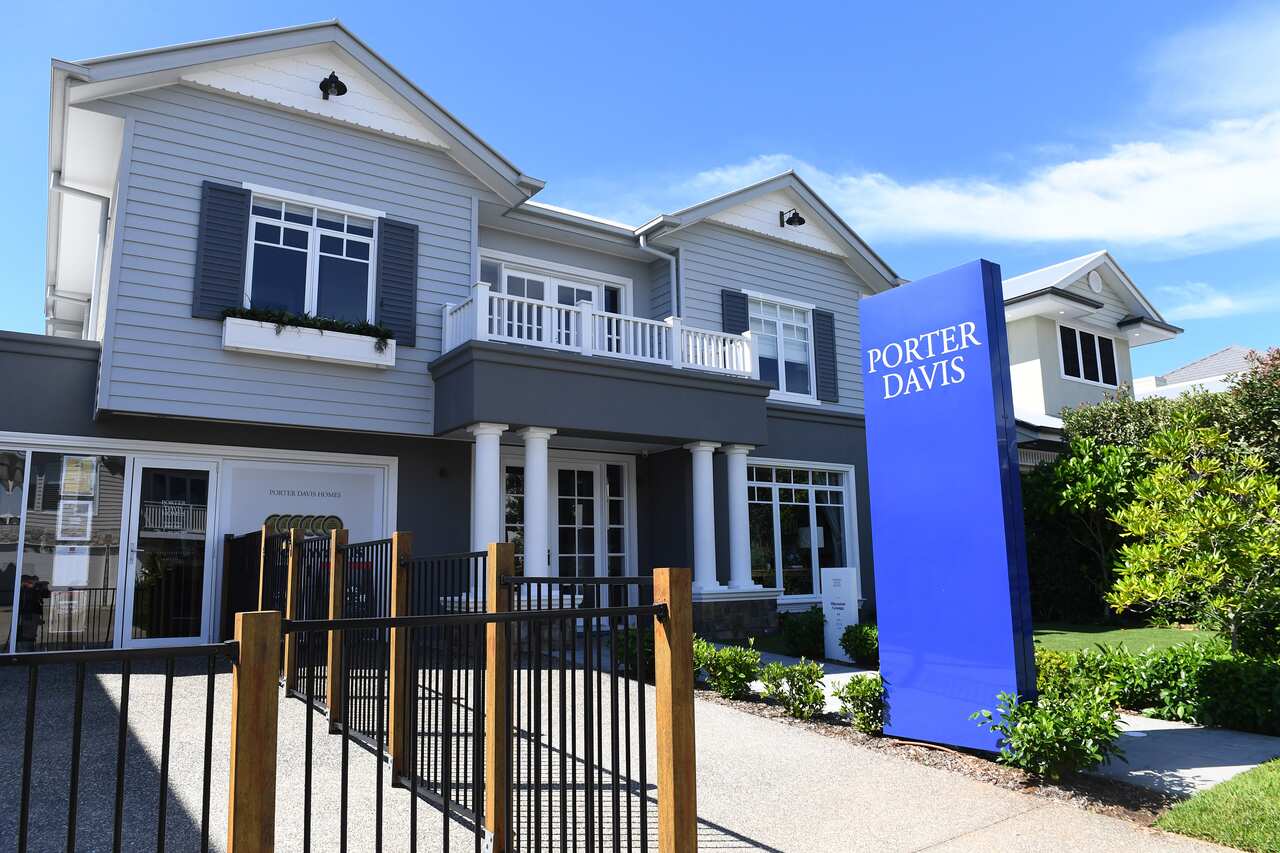 A white, blue and grey display home with a bright blue sign reading, Porter Davis at the front. 