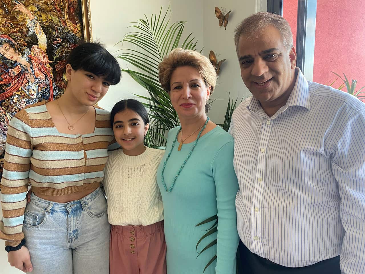 Sisters Hasti and Hedieh Rostami with their mother Jila Solaimani and father Reza Rostami, standing inside