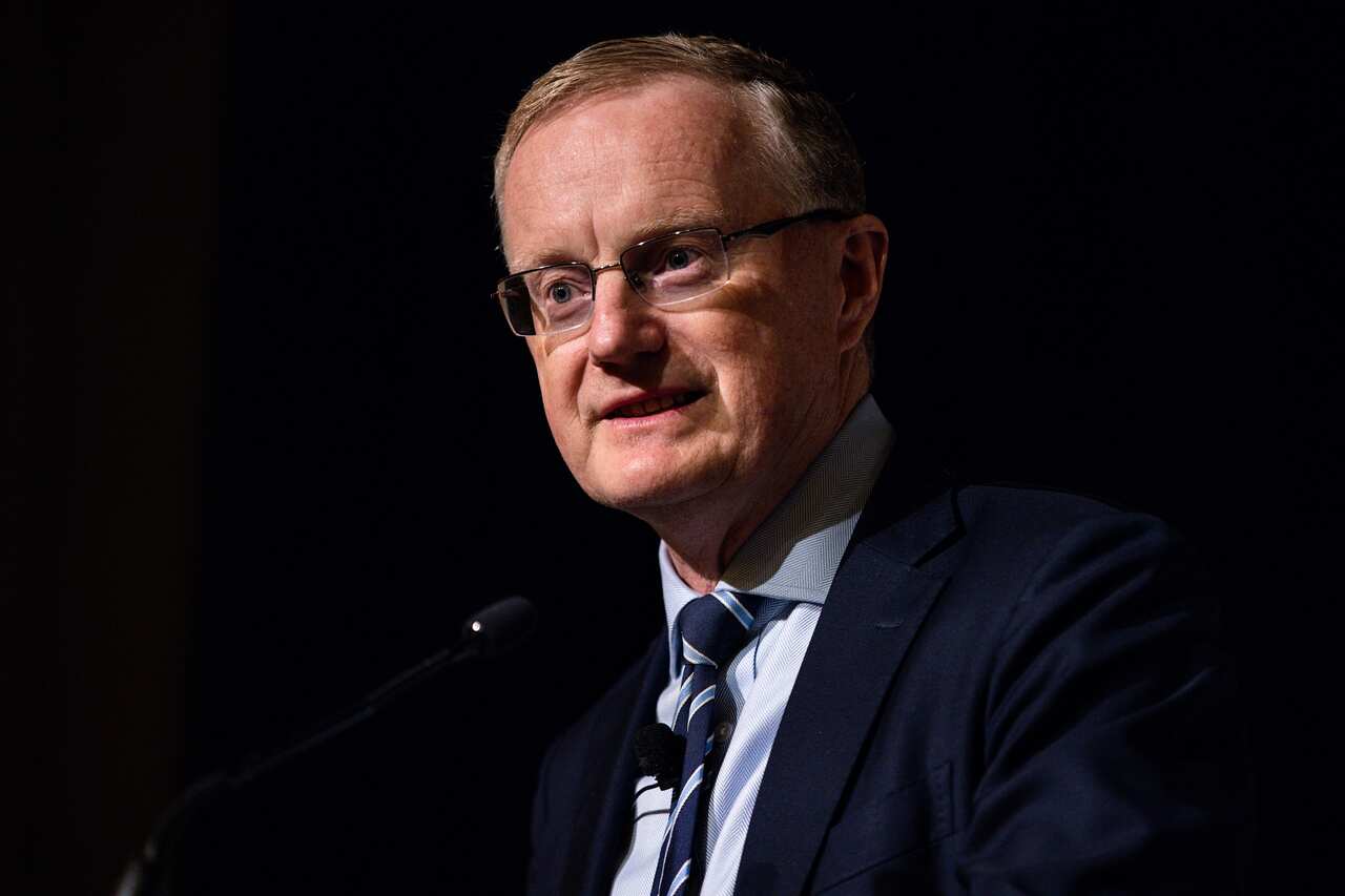 A man wearing a suit and tie who is speaking.