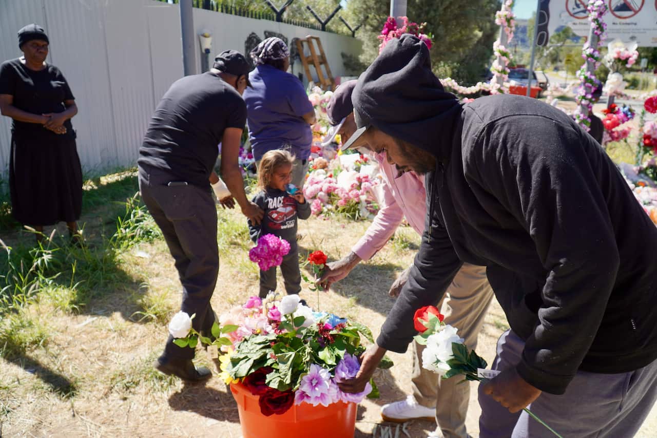 Members of Kumanjayi Little Baby's family lay flowers