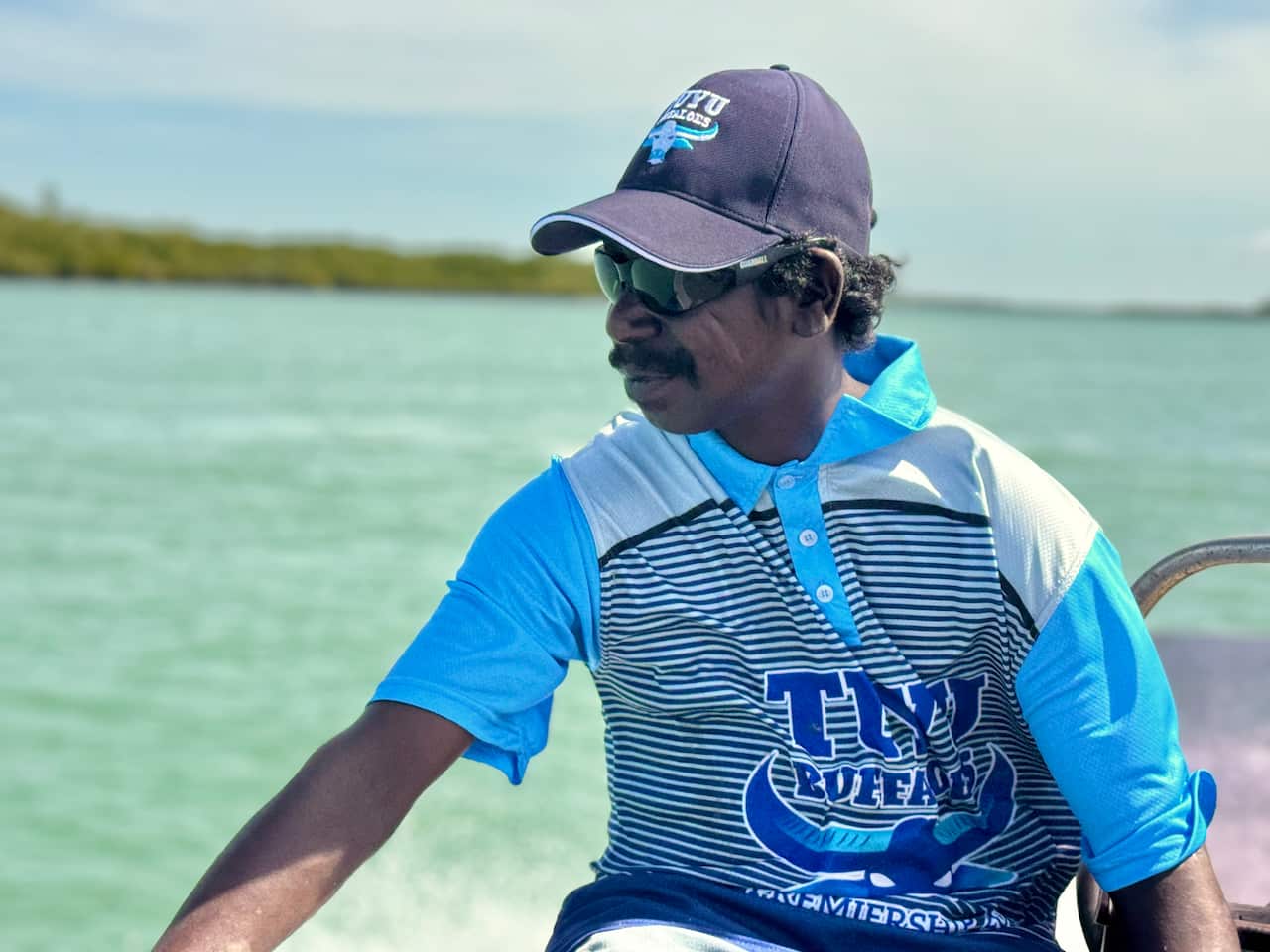Les on boat looking out at Tiwi Island landscape 
