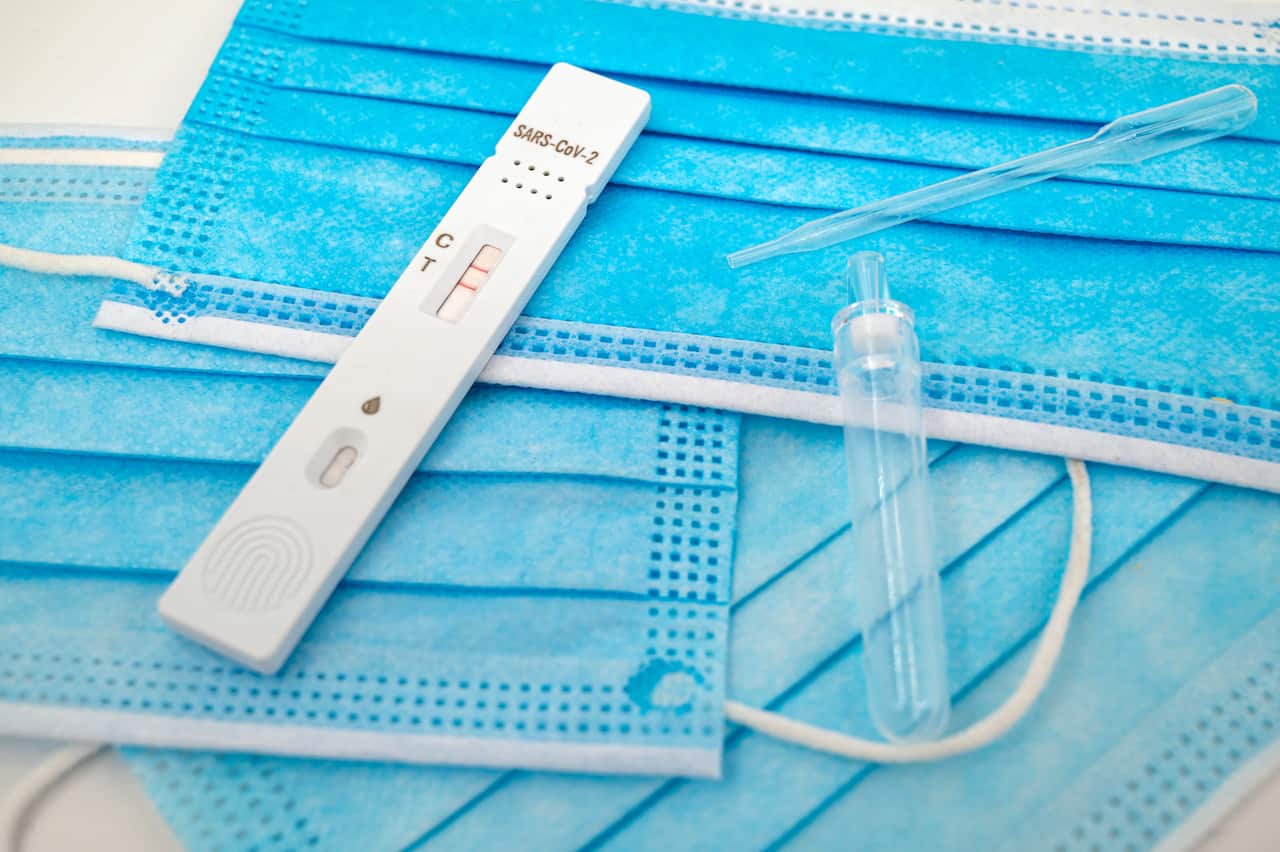 A positive COVID-19 test on top of protective face masks.