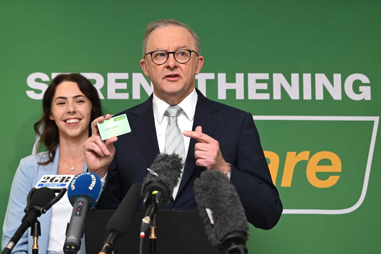 Anthony Albanese holds up a Medicare card.
