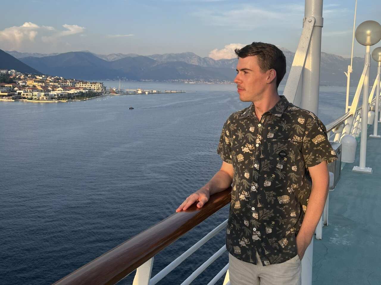 A young man on a cruise ship looking out over the ocean