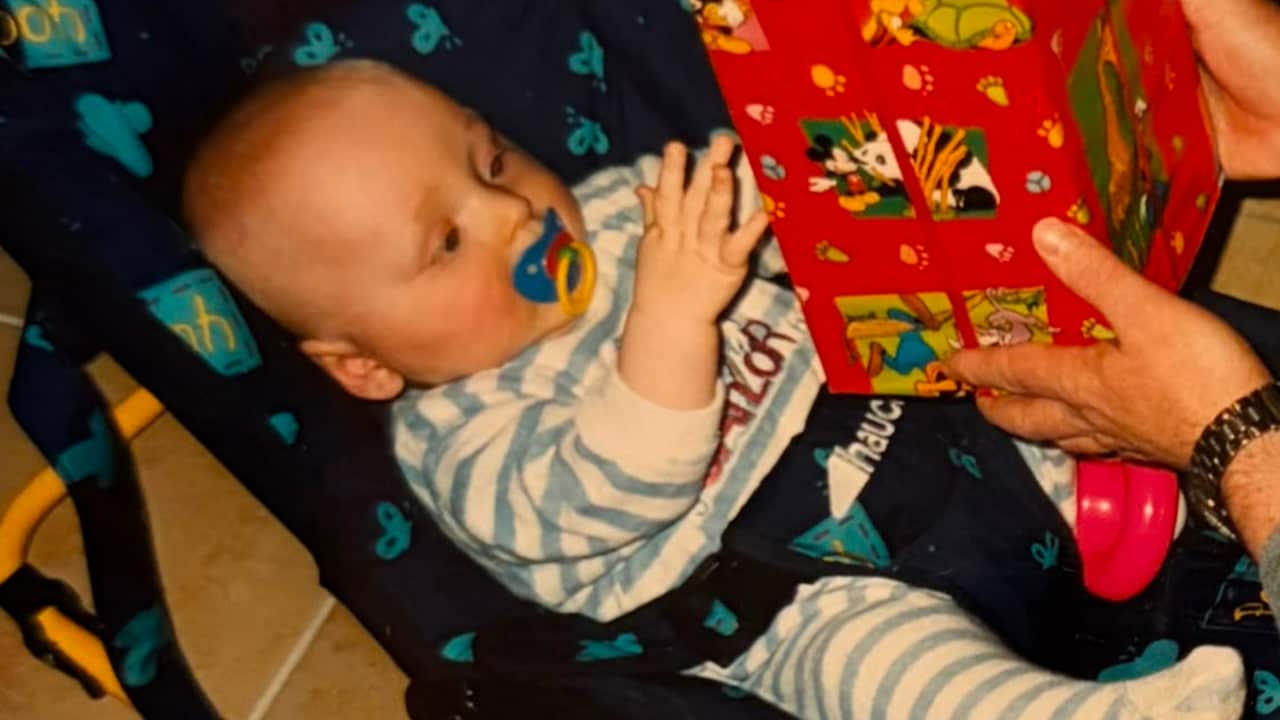 a baby in a rocker holding a present