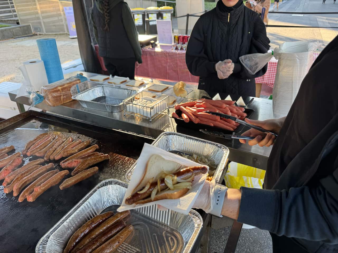 A sausage sandwich with onions on a serviette