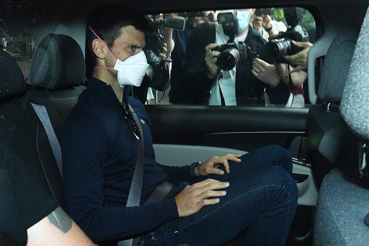 Novak Djokovic sits in the back of vehicle