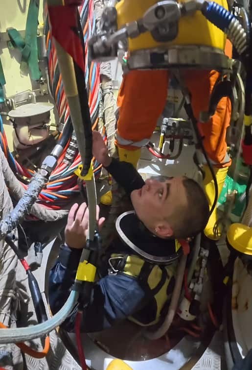 A commercial diver getting kitted up for a dive.