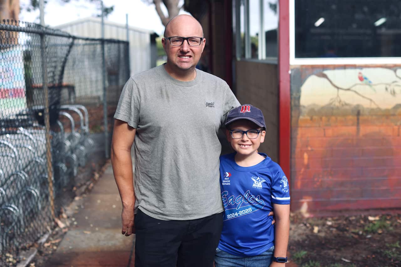 A man and his son poses for a photo outside an election booth in Perth.
