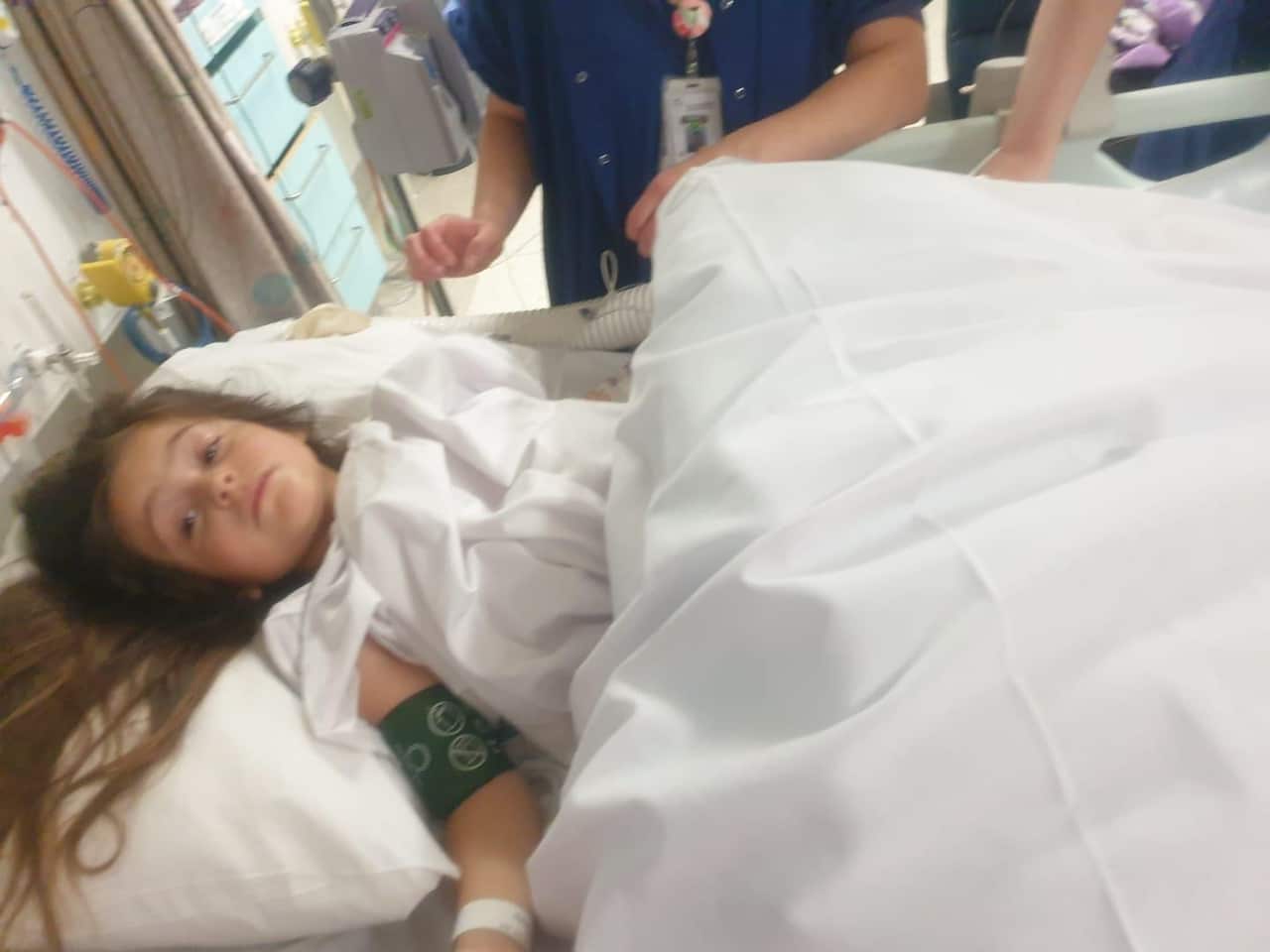 A girl lying in a hospital bed.