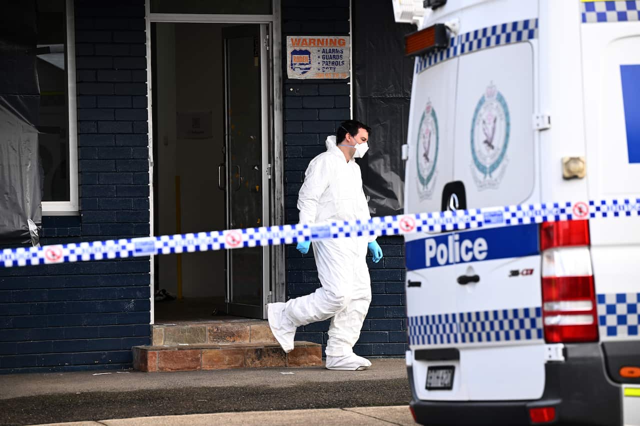 A man in PPE next to a police van