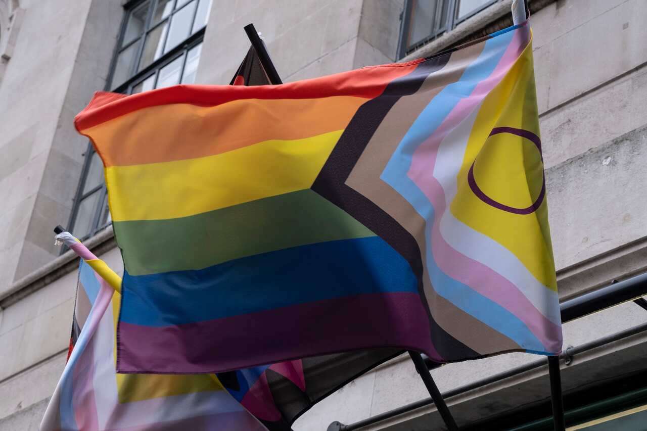 Intersex Progress Pride Flag waving in wind outside a building