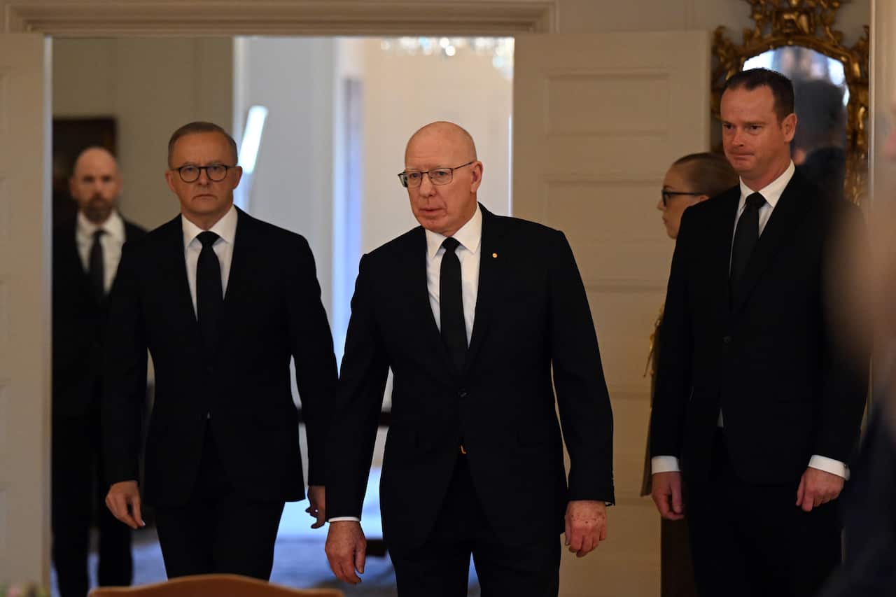 To men in black suits and ties walking.