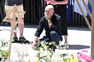 A man kneels at a memorial for the Bondi terrorist attack