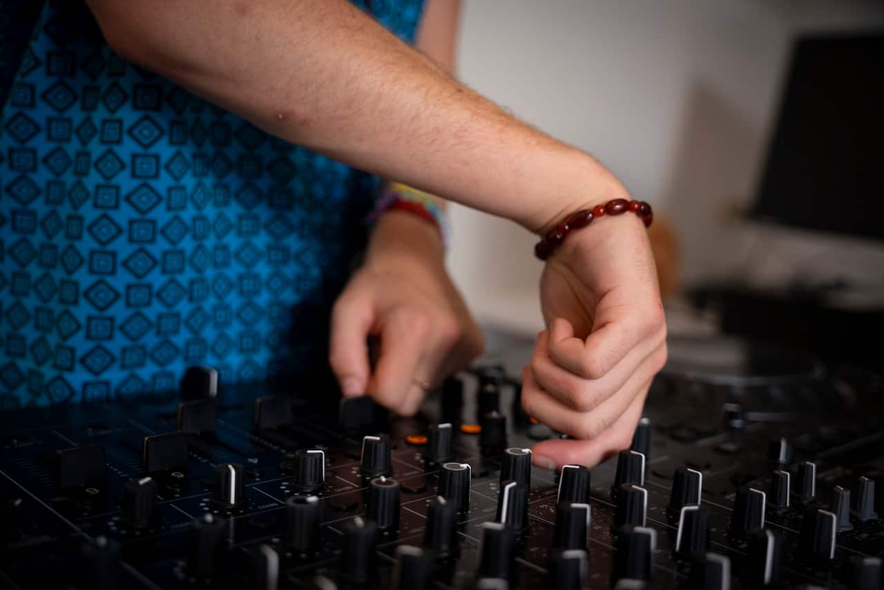 A person's hands using DJ equipment.