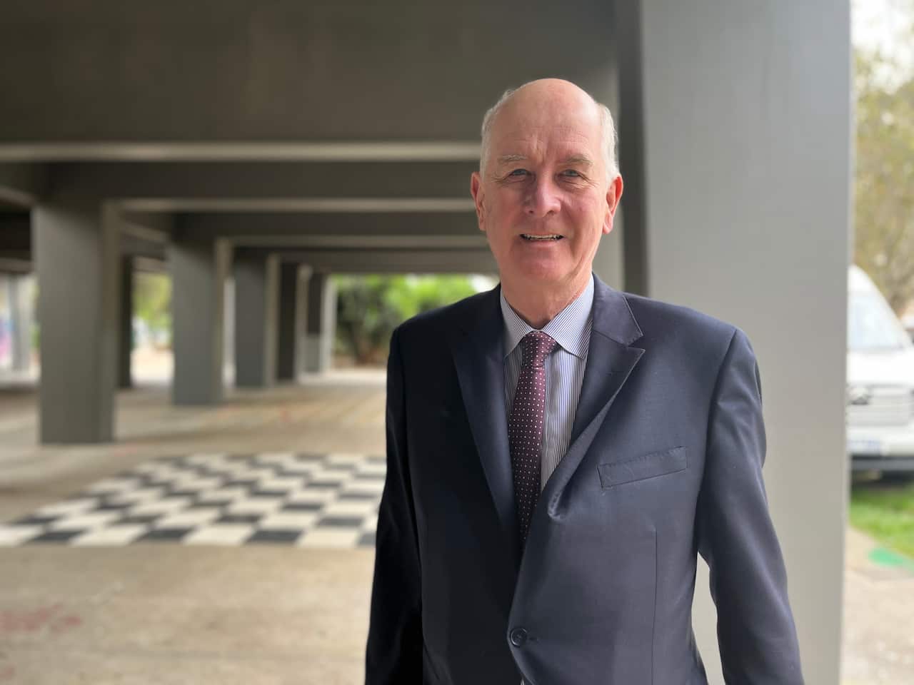 A man wearing a suit, standing outside