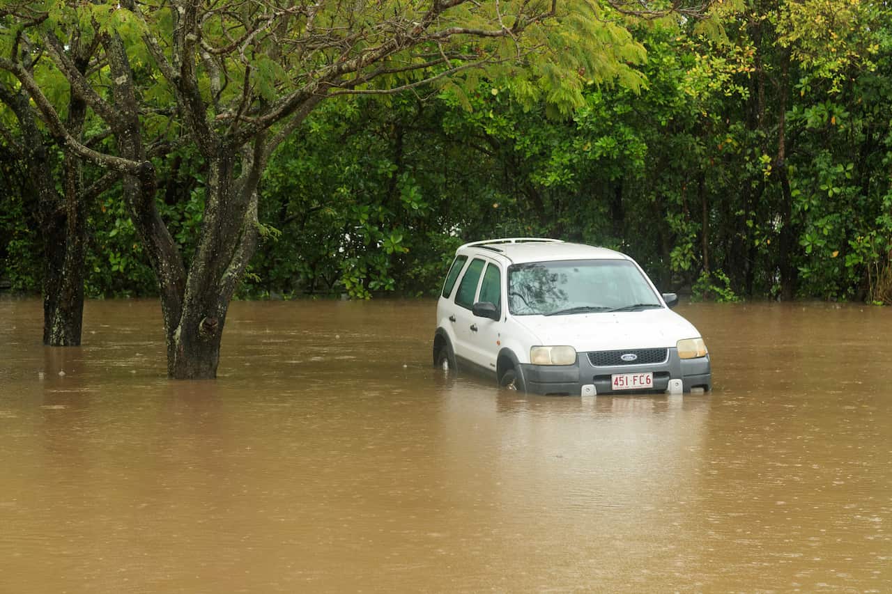 A white car stuck in floodwaters