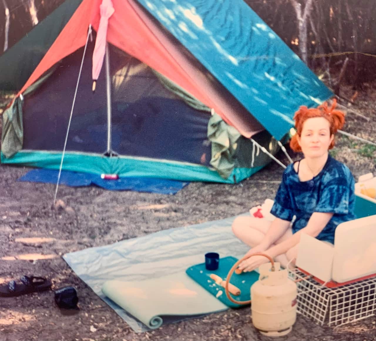 Jules Diamond sitting outside of tent cooking in the bush