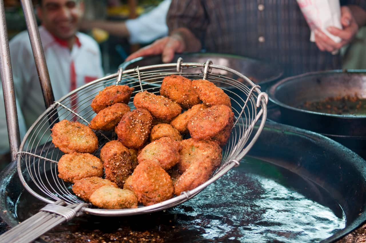 Falafel in a basket lifted out of hot oil in Cairo, Egypt