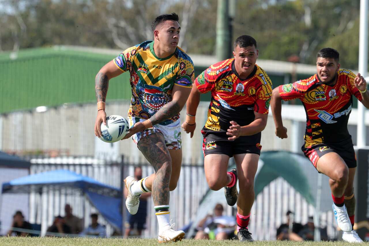 A player runs with the ball at a Koori Knockout match 