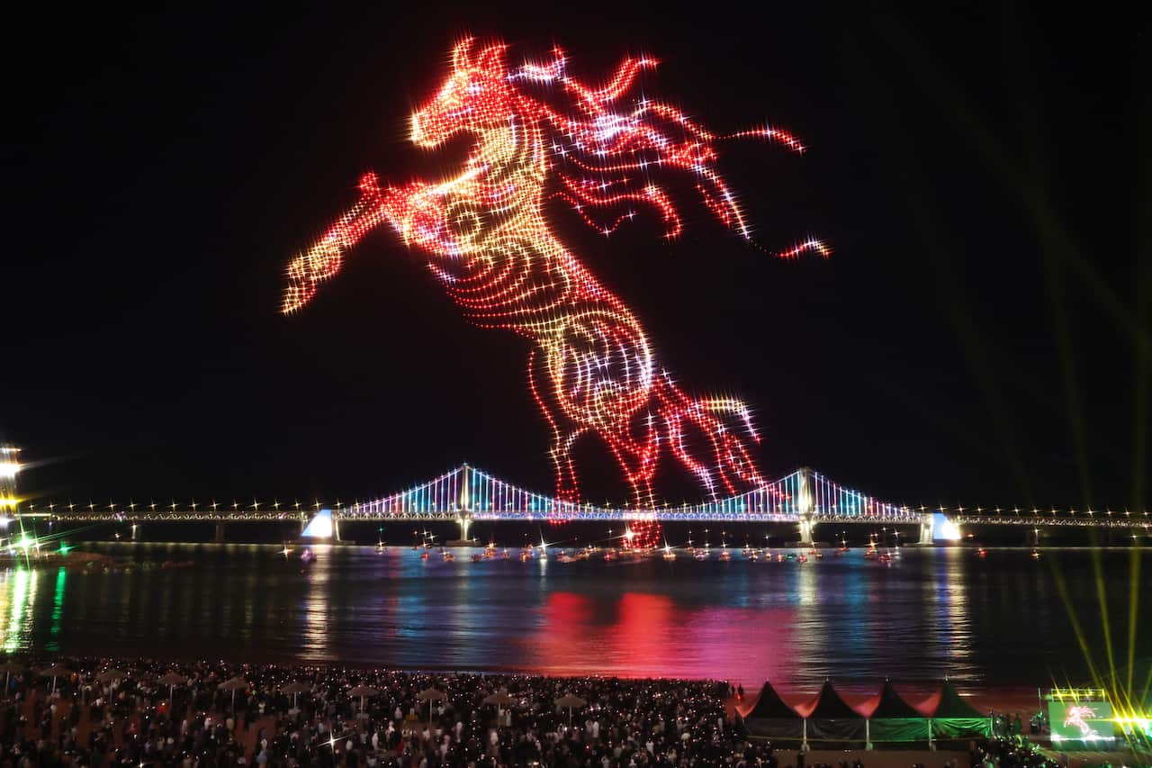 Lightshow in the shape of a horse by a river
