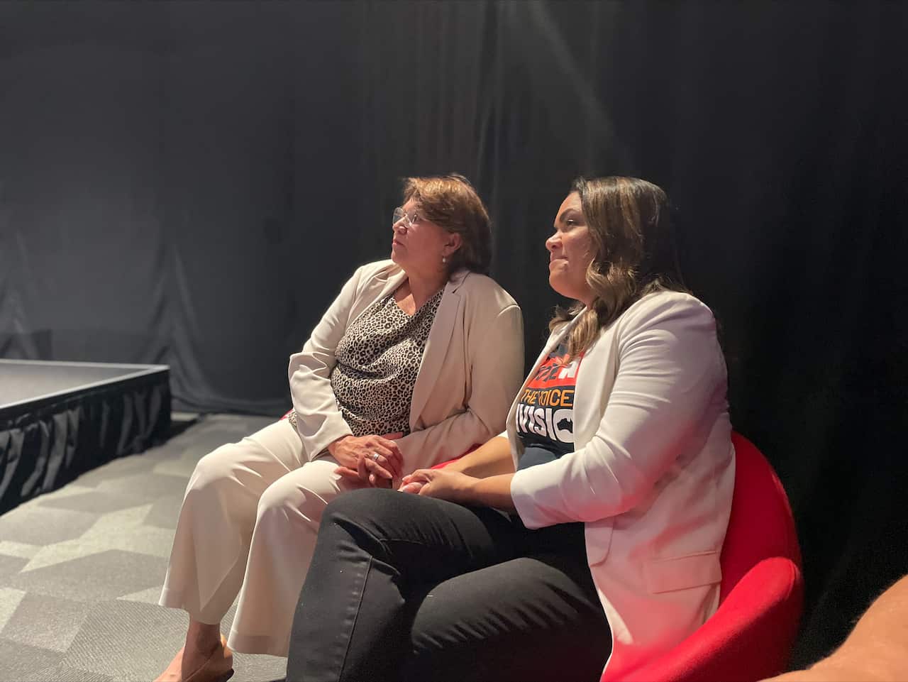 Kerrynne Liddle and Jacinta Nampijinpa Price sitting on chairs in an auditorium.