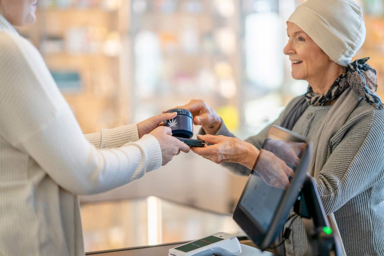 Store Clerk Handing a Customer her Purchase
