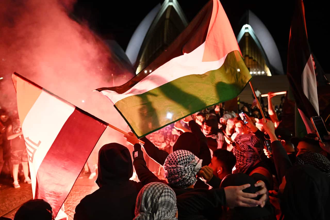 Some people wave flags, others let off flares outside the Sydney Opera House.
