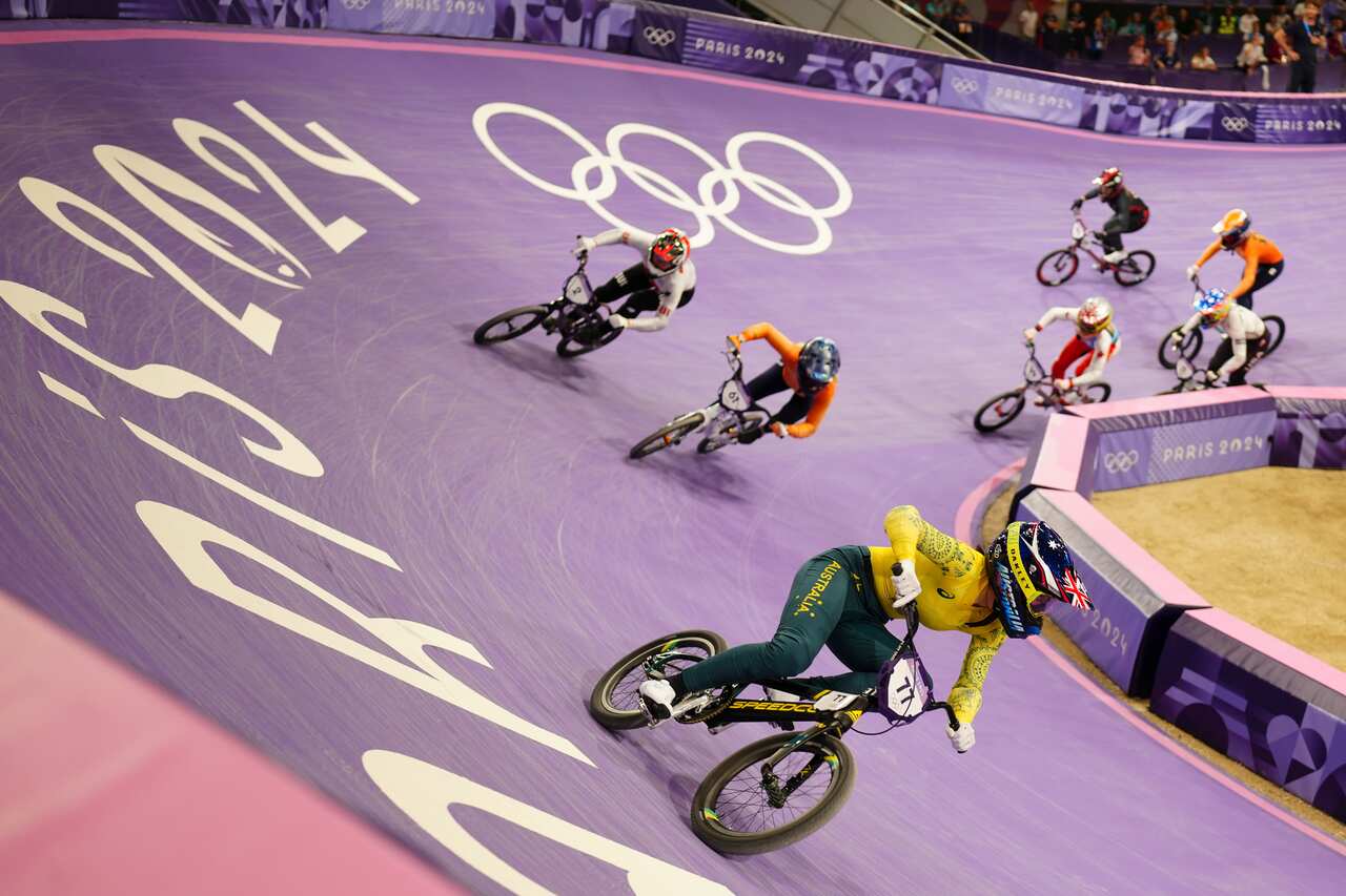 A group of seven BMX cyclists, with Saya Sakakibara leading. 