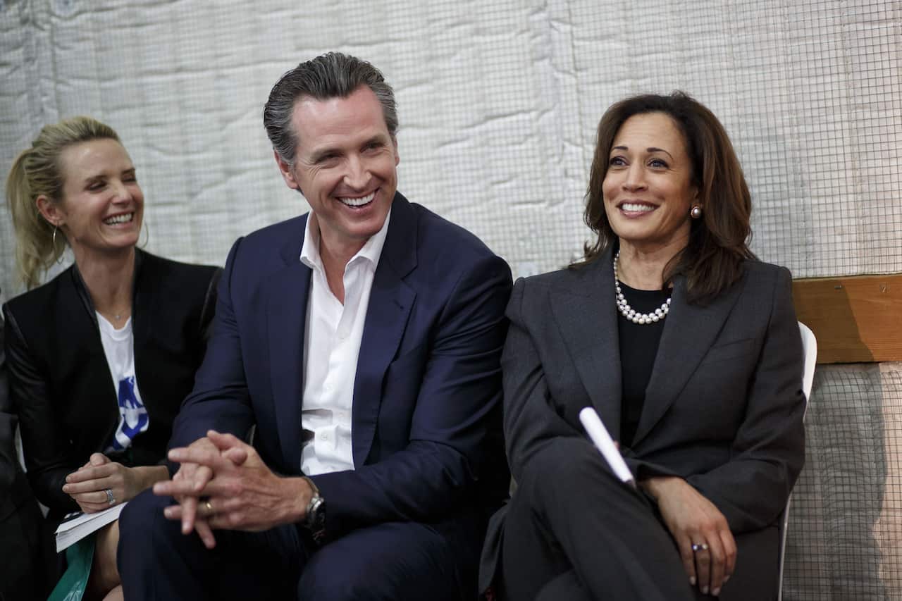 Kamala Harris and Gavin Newsom sitting side by side and laughing.