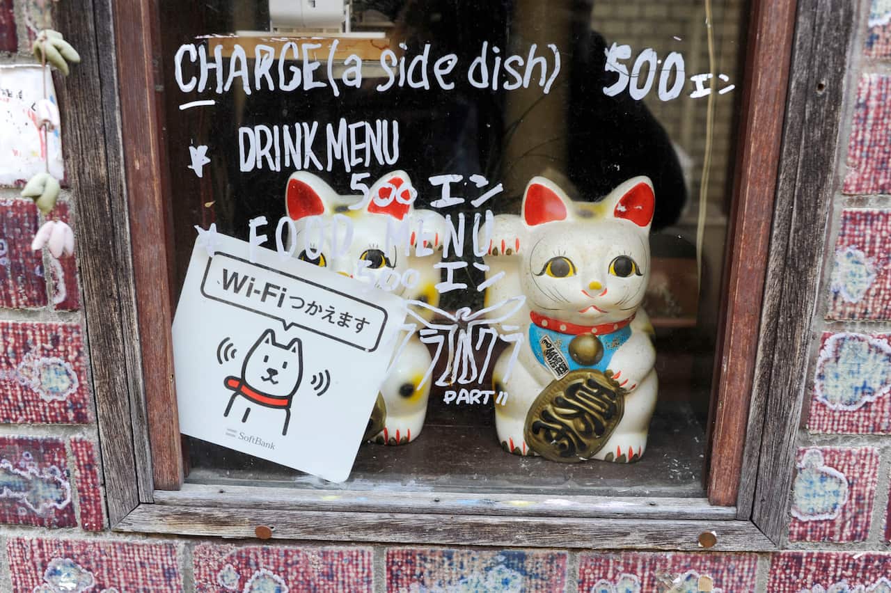 Two maneki-neko cat dolls in a window display