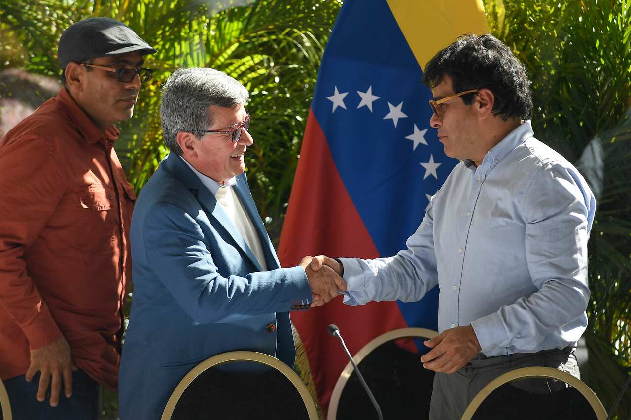 Venezuela Colombia ELN Peace Talks. Pablo Beltran, representing the Colombian guerrilla National Liberation Army (ELN), front left, shakes hands with Ivan Danilo Rueda, High Commissioner for Peace on behalf of the Colombian government, after a press conference at the end the first part of peace talks at the Humboldt Hotel in Caracas, Venezuela, Monday, Dec. 12, 2022. (AP Photo/Matias Delacroix)