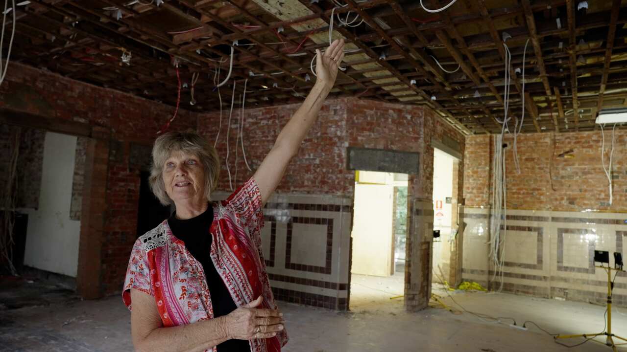 Mieke Bell pointing to the roof of the gutted ground floor of the Winsome and Lismore Soup Kitchen.