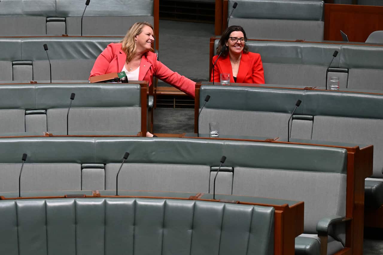 Two women sitting on the benches in the House of Representatives.