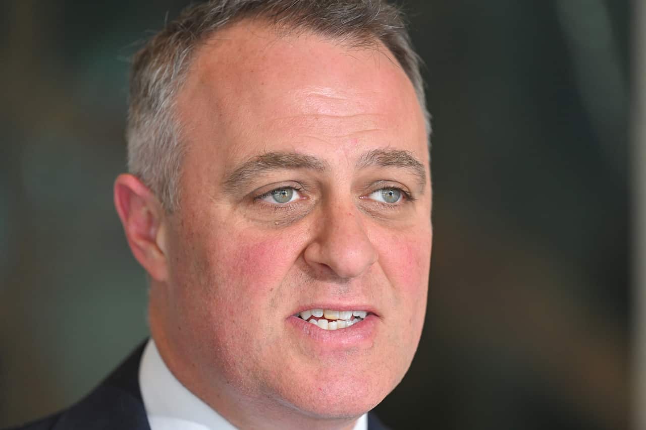 Tim Wilson, in front of a blurred background, speaking.
