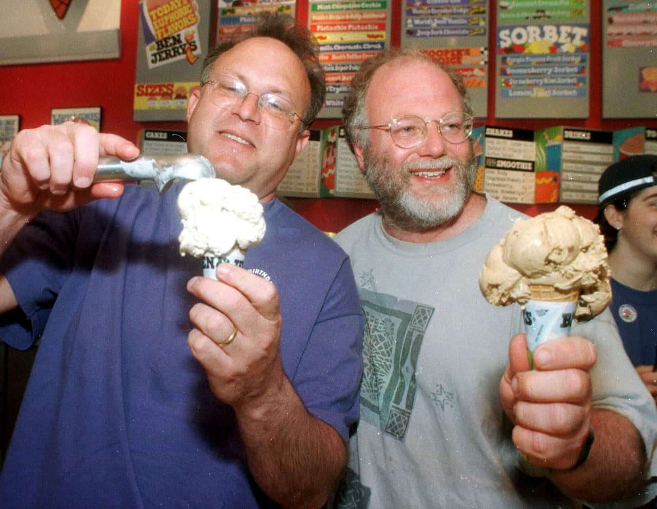 Two men holding ice cream cones in their hands.