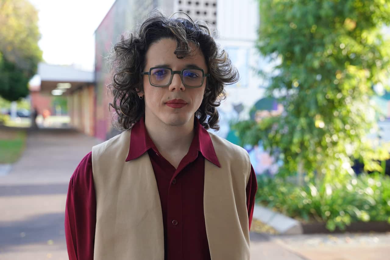 [JVS] A person with glassses and brown hair showing little expression