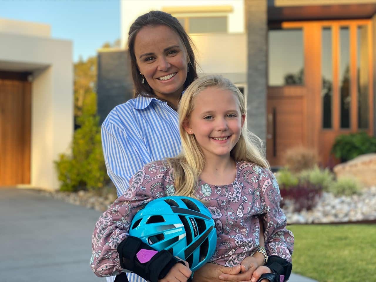 A woman and her daughter, both smiling