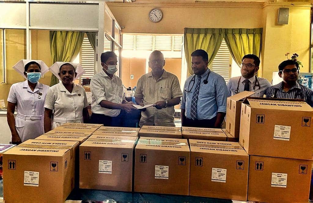 Hospital staff stand behind large boxes which are fill of antibiotic medications.