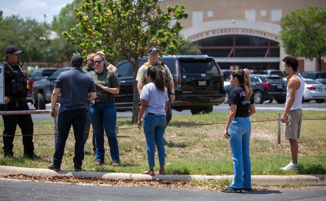 A law enforcement officer speaks with people