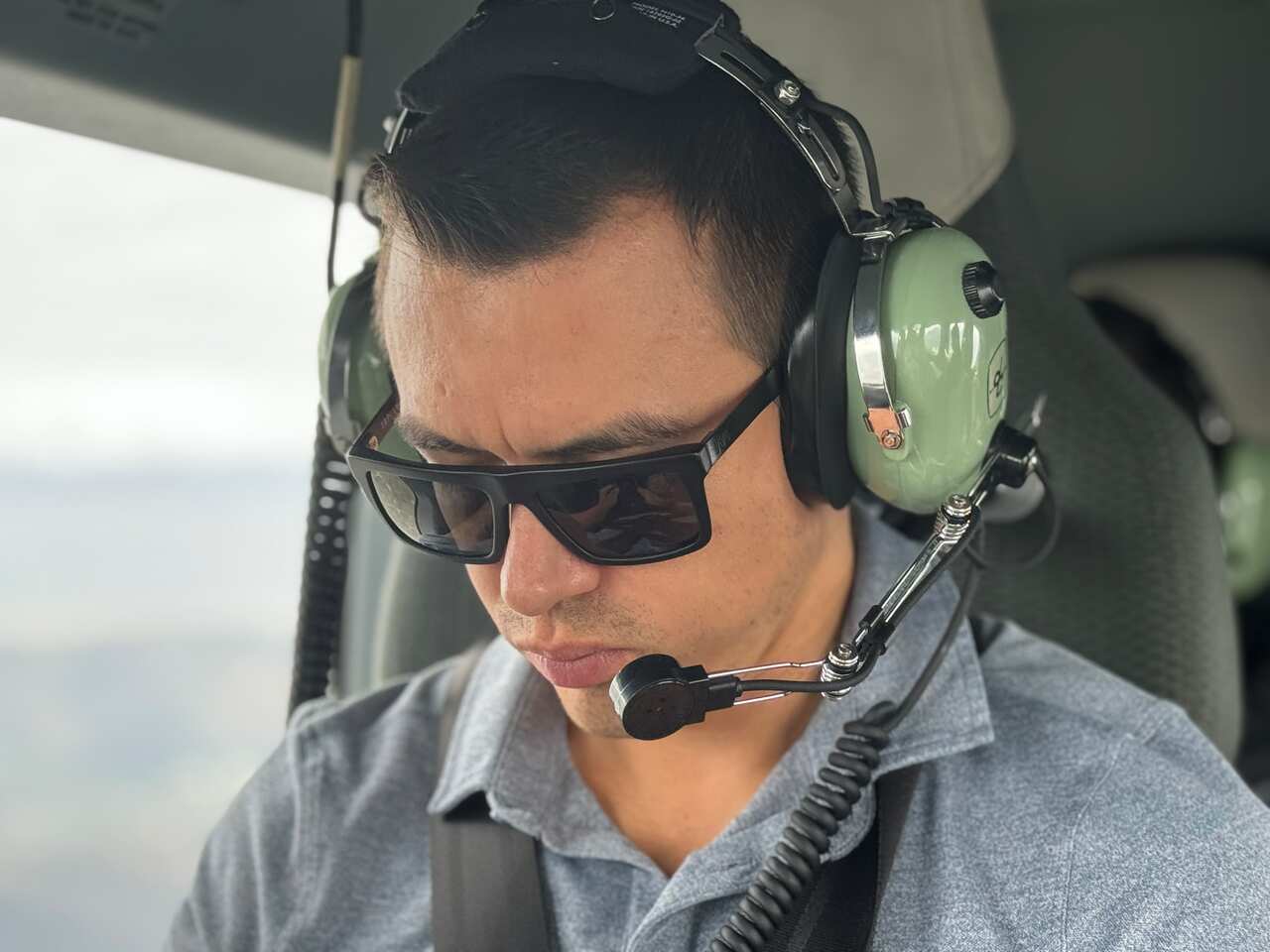 A man wearing sunglasses and green headphones