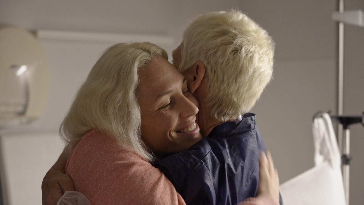 A woman embracing another woman.