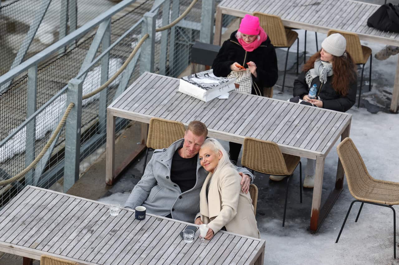 People seated at tables outdoors.